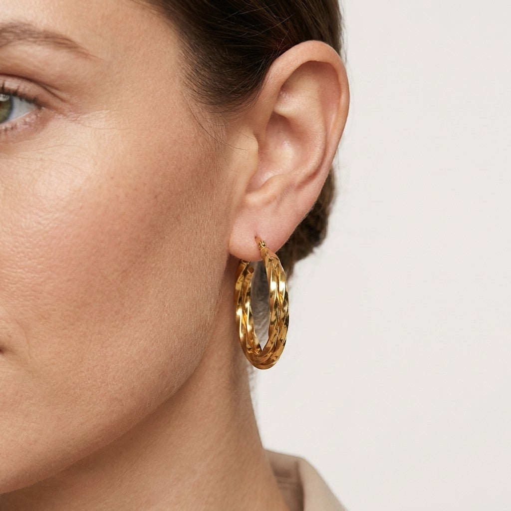 Aramat Jewels gold-tone twisted triple hoop earrings, 30mm diameter, made of stainless steel with gold plating.