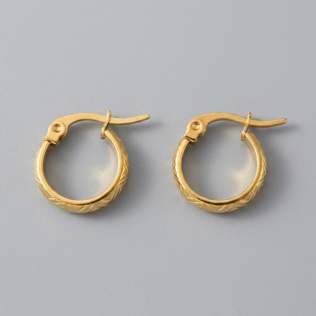 Aramat Jewels small gold-tone stainless steel hoop earrings with a textured zigzag pattern and hinge closure.
