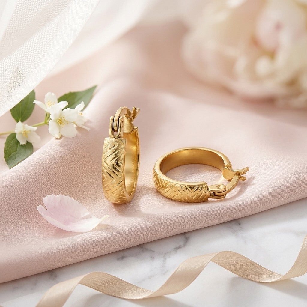 Aramat Jewels small gold-colored stainless steel hoop earrings with a zigzag pattern, 10mm diameter.