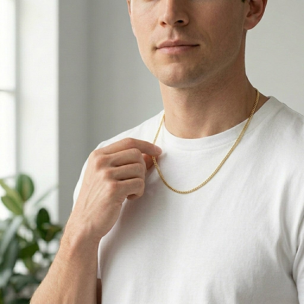 Aramat Jewels gouden gourmet ketting van 2mm breed roestvrij staal gedragen door een man met een wit t-shirt.
