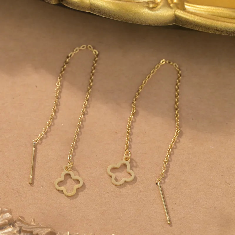 Aramat Jewels goudkleurige doortrek oorbellen van RVS met een elegante open bloemhanger aan een fijn kettinkje.