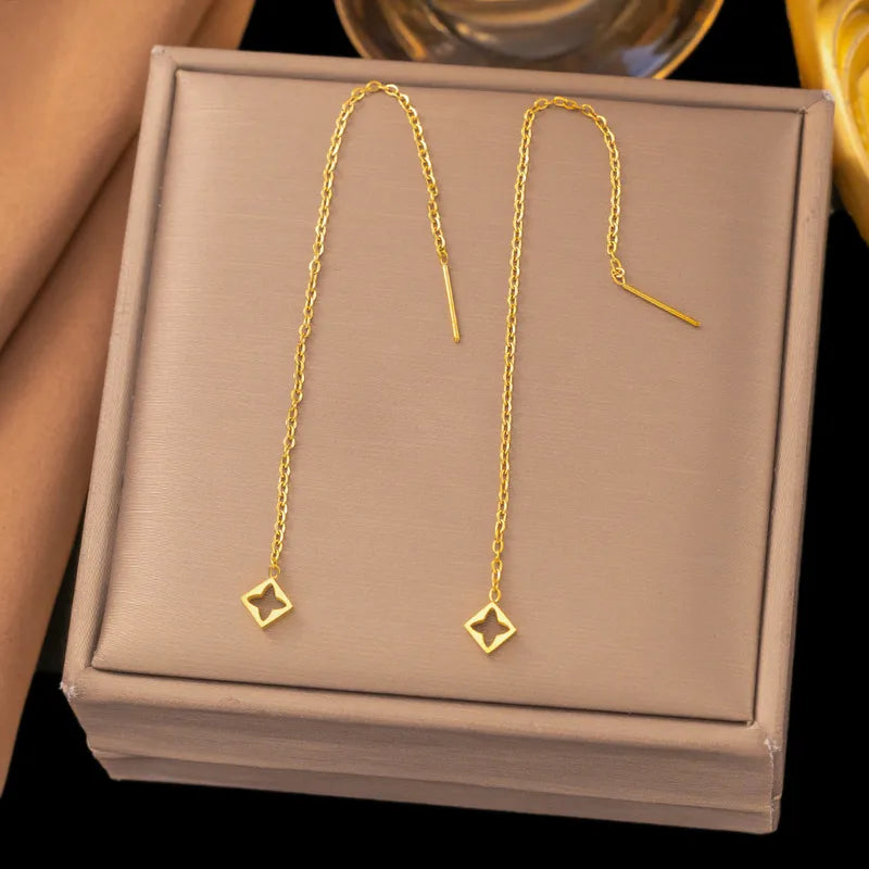 Aramat Jewels goudkleurige RVS doortrek oorbellen met een vierkante hanger en open bloemmotief, 8 cm lang.
