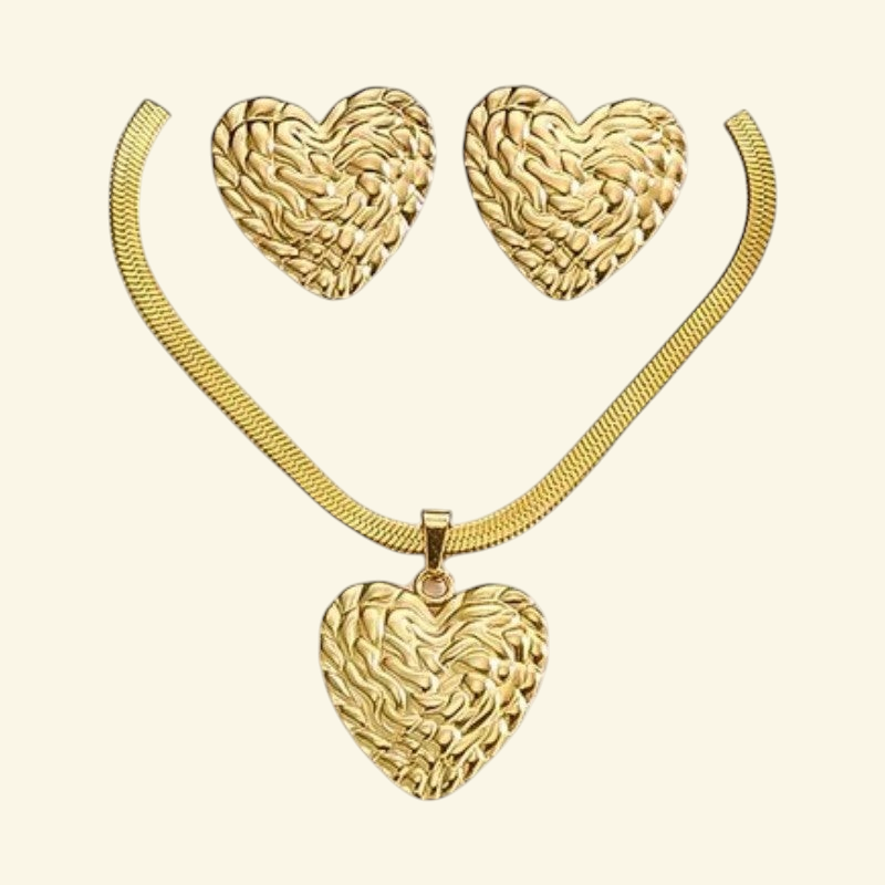 Aramat Jewels goudkleurige RVS sieradenset met een bewerkte harthanger aan een platte slangenketting en hartoorbellen.