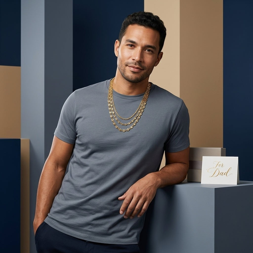 Man draagt een goudkleurige Aramat Jewels koffieboon ketting van 5,2mm breed en 60cm lang in een stijlvolle setting.