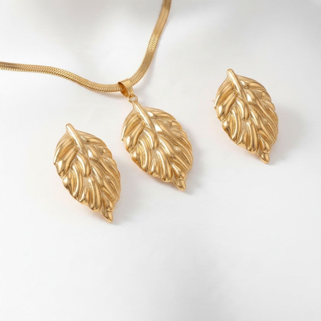 Aramat Jewels goudkleurige RVS sieradenset met een slangenketting en oorbellen in een elegant bladvormig ontwerp.