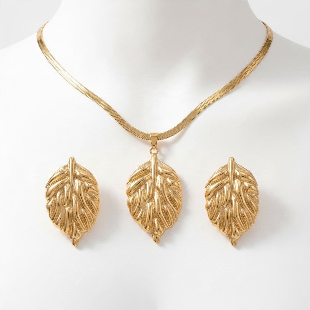 Aramat Jewels goudkleurige RVS sieradenset met een slangenketting en bijpassende oorbellen in een bladvormig design.