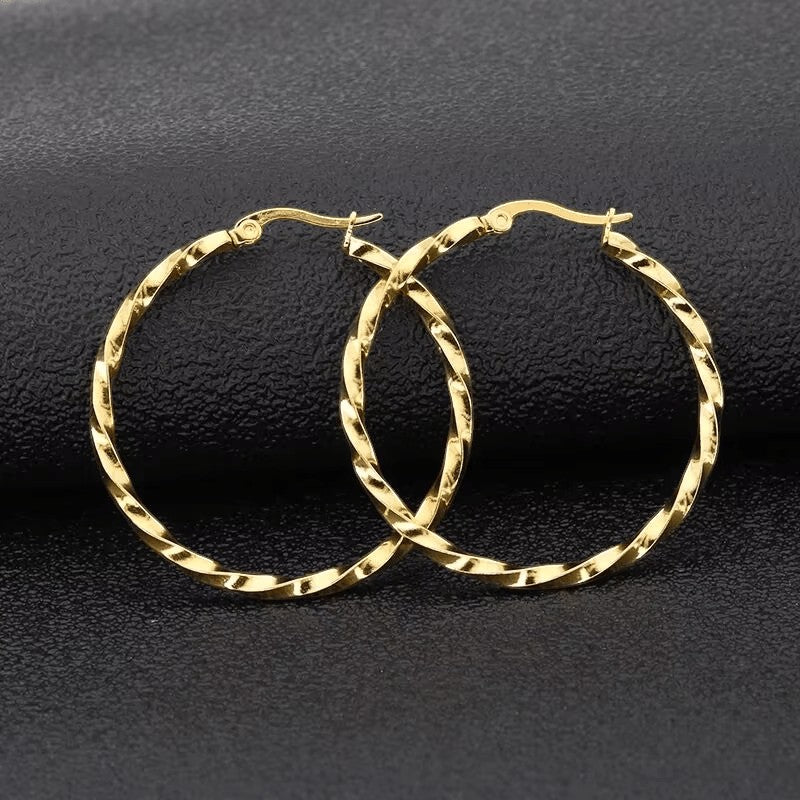 Aramat Jewels Goudkleurige RVS swirl hoepeloorbellen 30 mm met scharniersluiting.