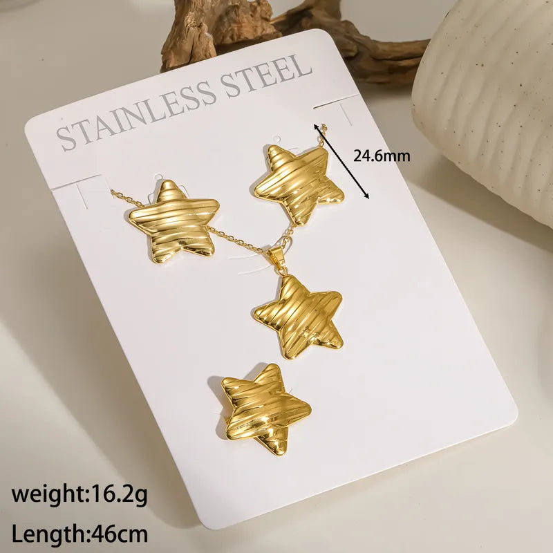 Aramat Jewels goudkleurige RVS sieradenset met sterhangers voorzien van een gestreept motief op een displaykaart.