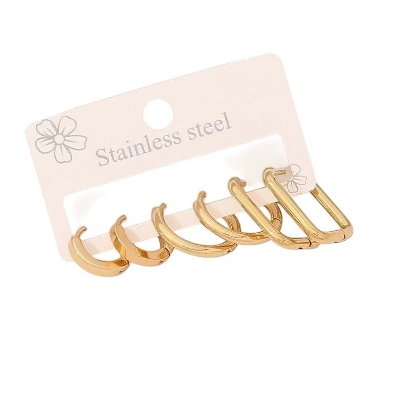 Aramat Jewels goudkleurige stainless steel oorringenset met twee ronde en één rechthoekig paar op een displaykaart.