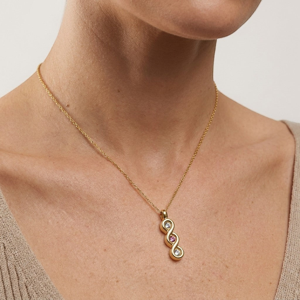 Aramat Jewels® goudkleurige stalen ashanger met zirkonia en roze steen, zonder ketting.