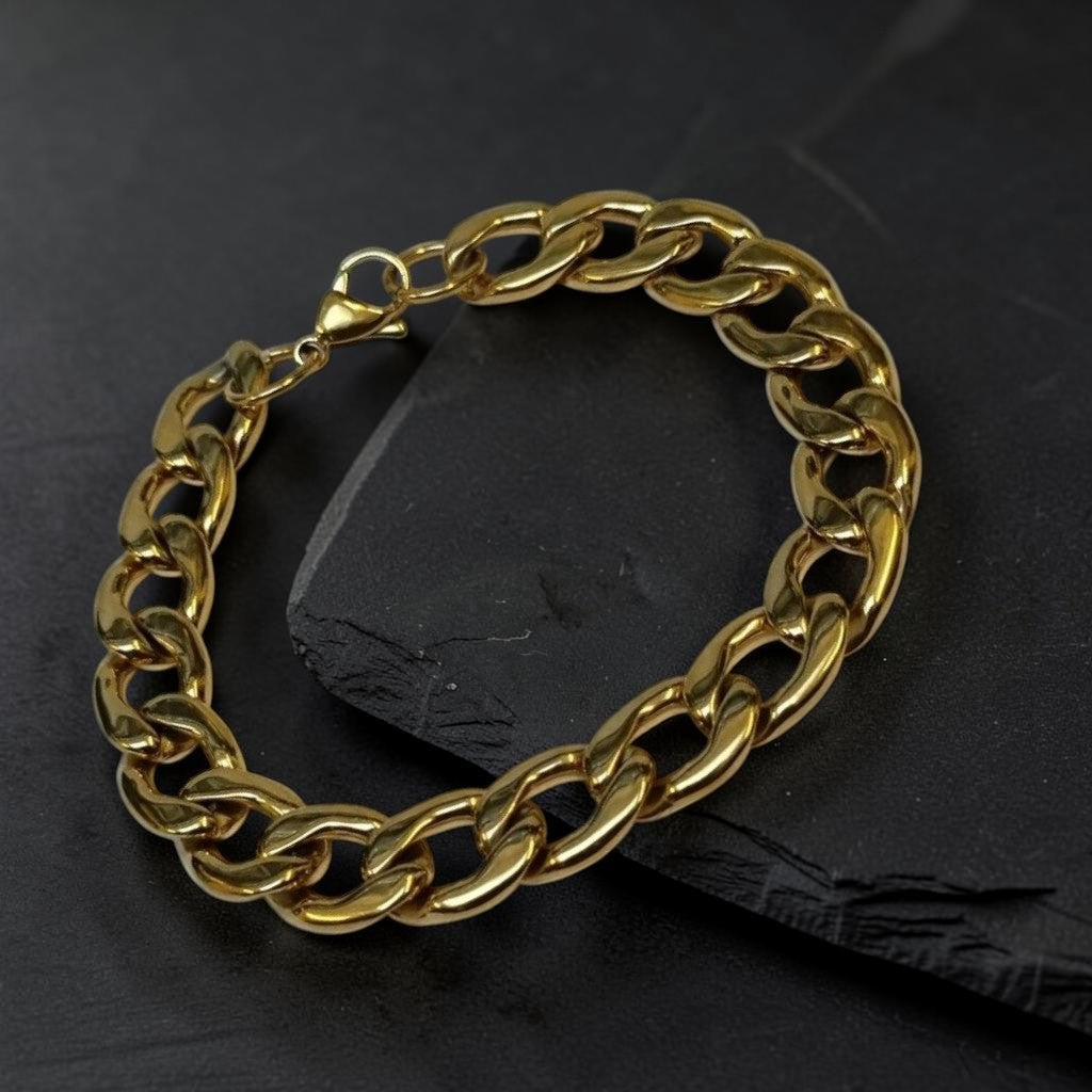 Aramat Jewels goudkleurige stalen gourmetarmband met steentjes op een zwarte leistenen ondergrond.
