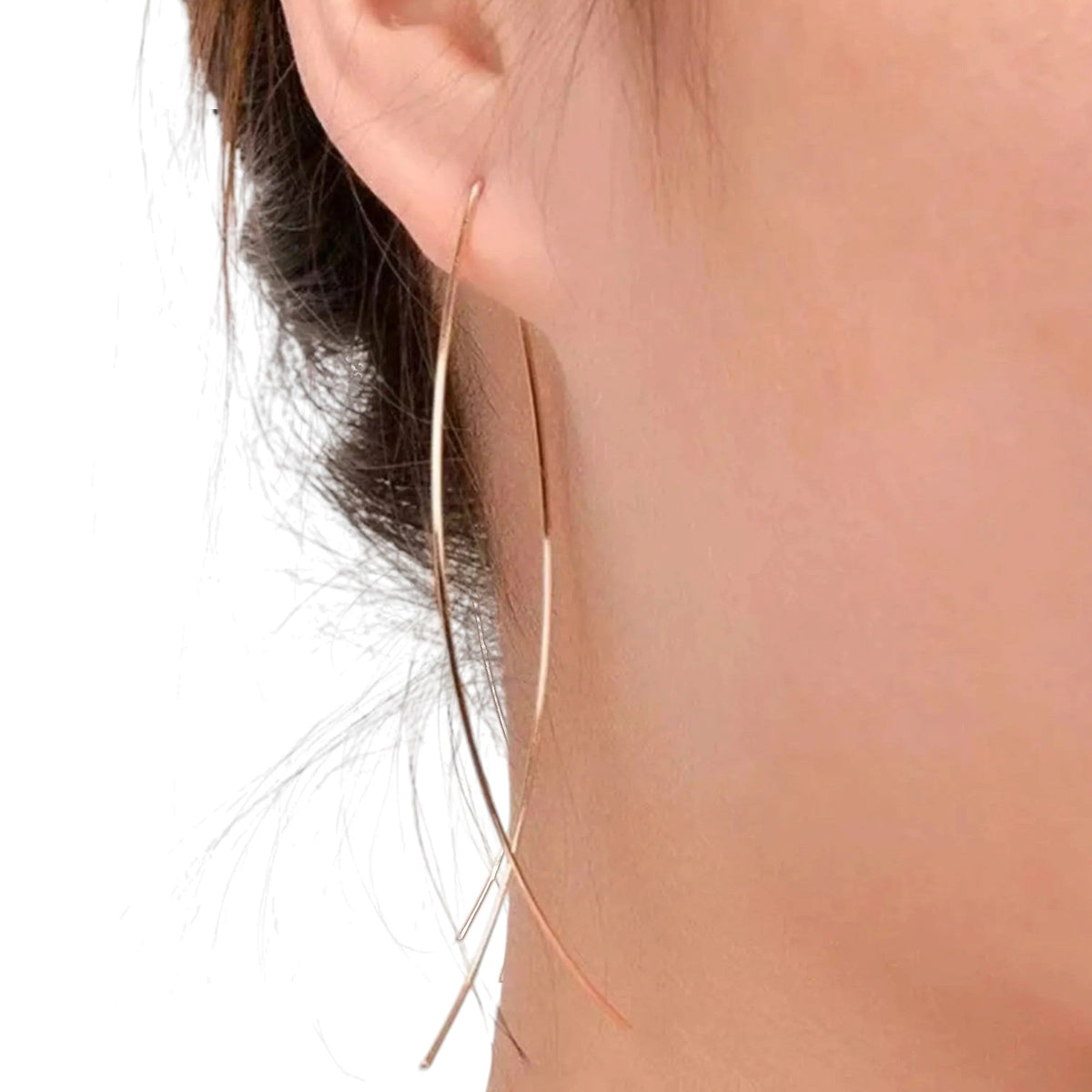 Aramat Jewels goudkleurige doortrek oorbellen met een geometrisch visontwerp gedragen in een oor