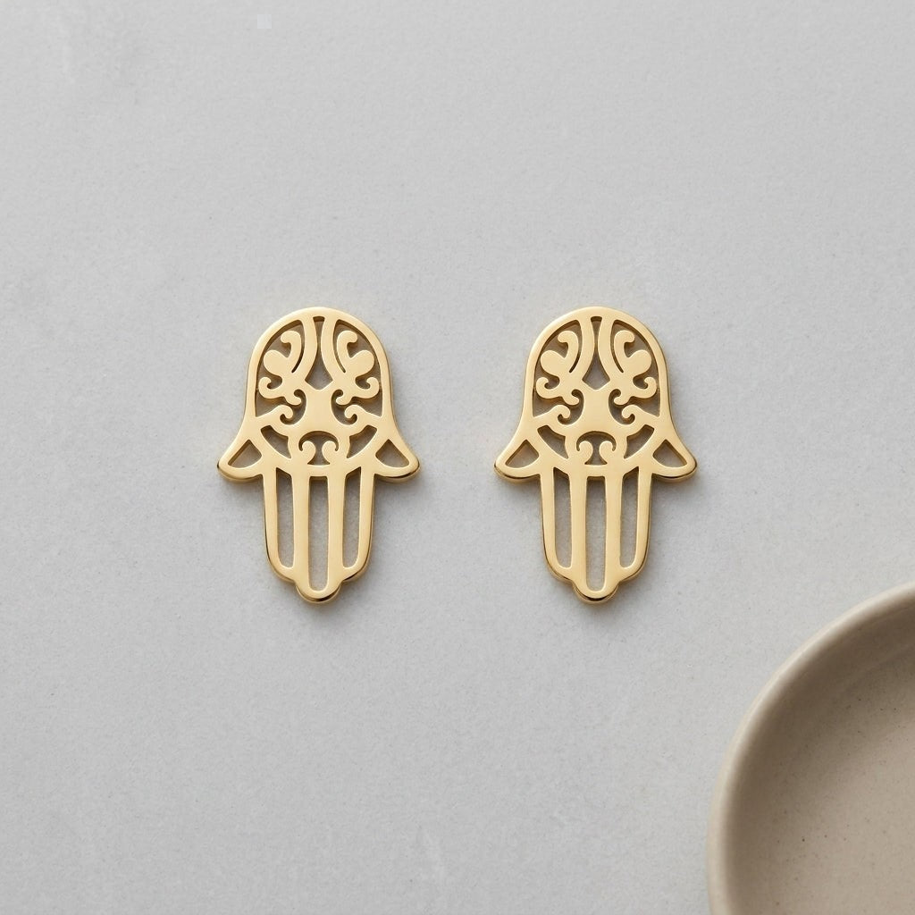 Aramat Jewels goudkleurige Hamsa oorknopjes van RVS met een verfijnd opengewerkt Handje van Fatima symbool.