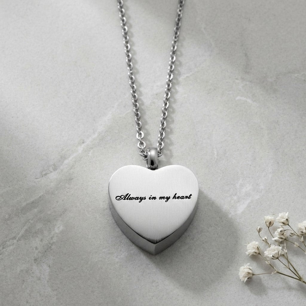 Aramat Jewels silver-tone stainless steel heart-shaped cremation pendant necklace with "Always in my heart" engraving.
