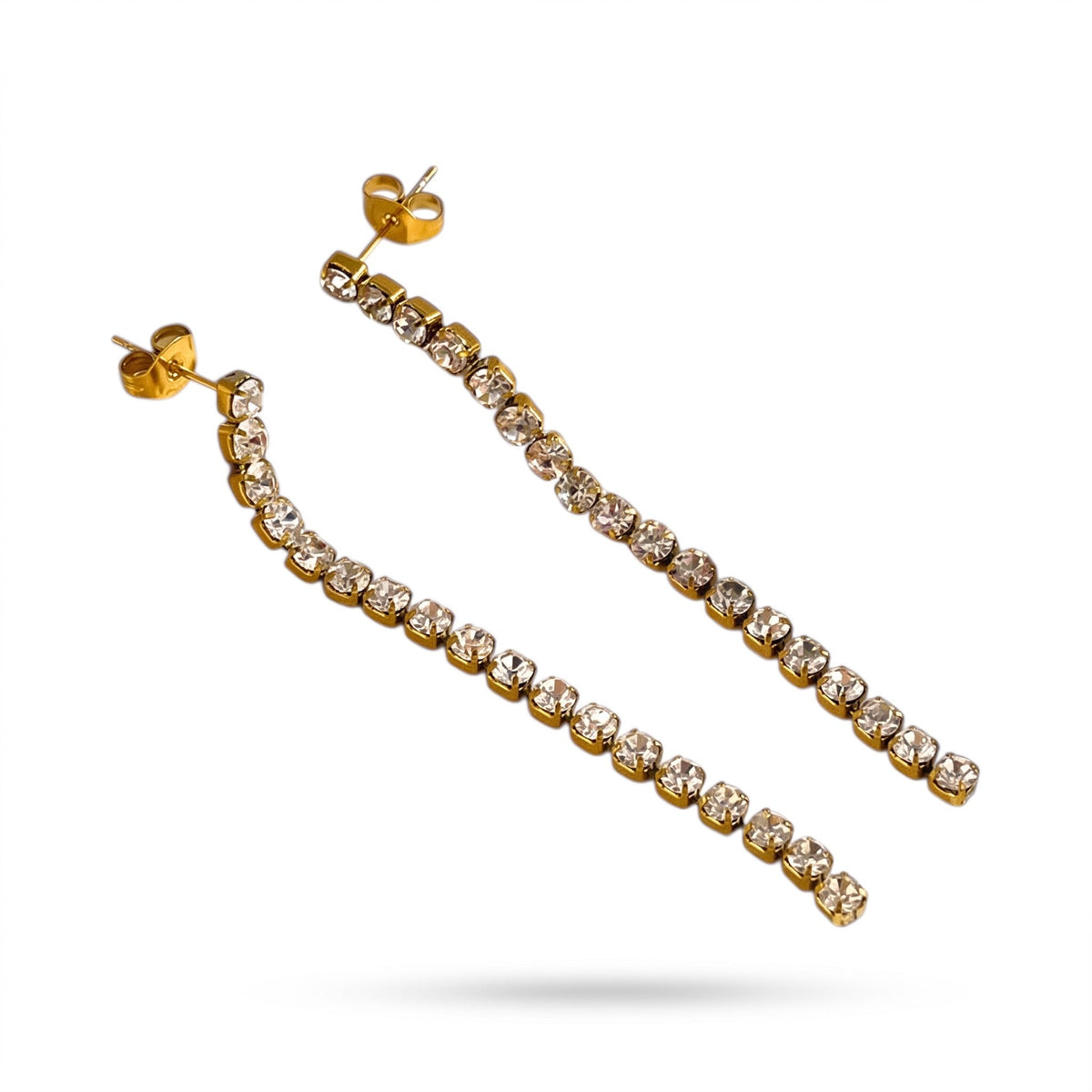 Aramat Jewels lange goudkleurige RVS oorhangers met een rij transparante kristalsteentjes en vlindersluiting.