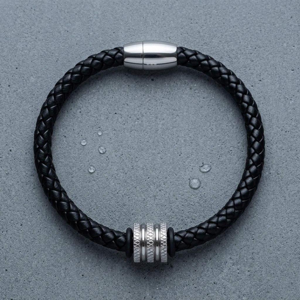 Aramat Jewels zwarte leren herenarmband met zilverkleurige RVS kraal en stevige magneetsluiting op grijze ondergrond.