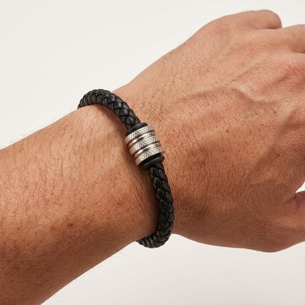 Aramat Jewels stoere zwarte gevlochten leren herenarmband met een zilverkleurige RVS kraal om een pols.