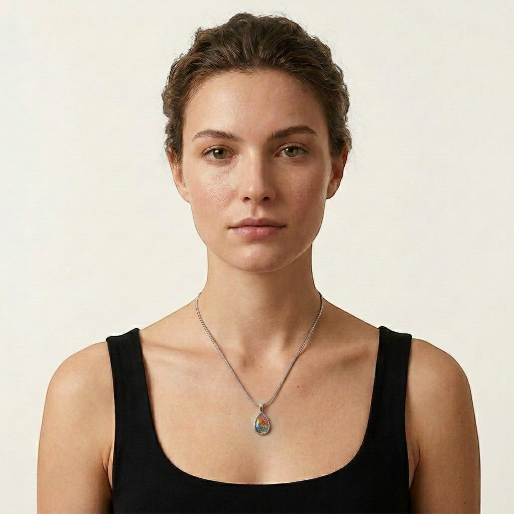 Aramat Jewels silver teardrop cremation pendant with colorful Murano glass floral inlay on a model.