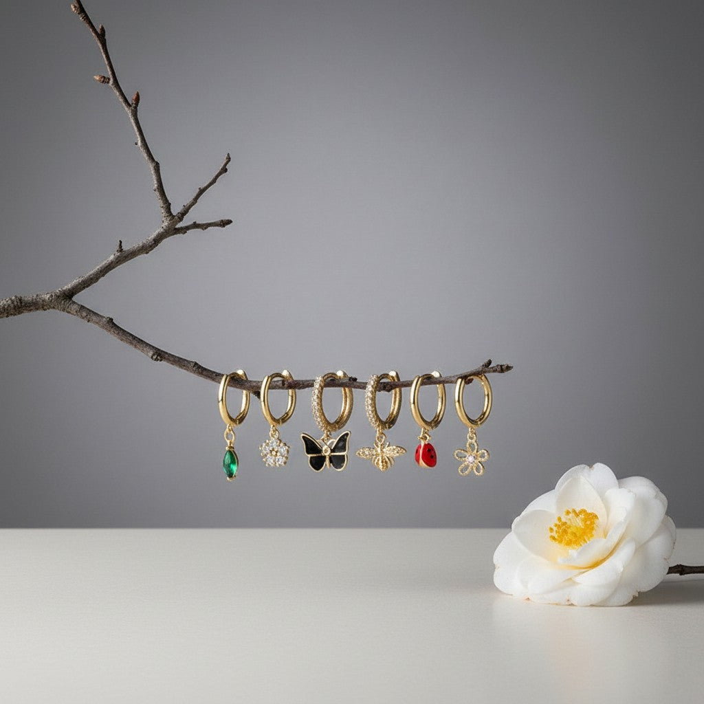 Aramat Jewels set of 6 gold-plated 925 silver hoop earrings with nature-themed charms: green marquise gem, white flower, black butterfly, bee, ladybug, and pink flower.