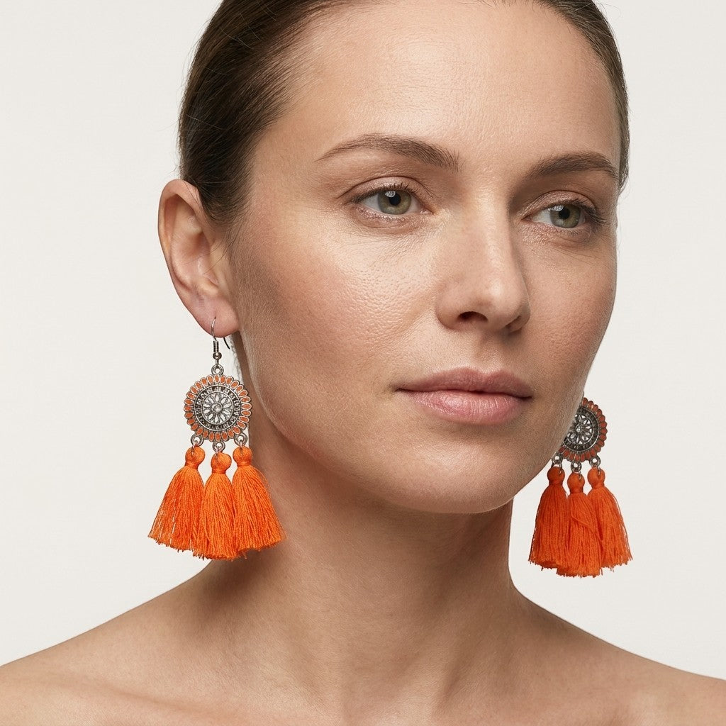 Aramat Jewels oranje boho oorhangers met kwastjes en zilverkleurige details. 75mm lang.