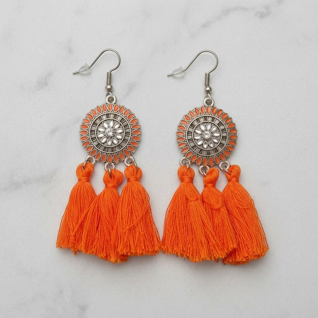 Aramat Jewels oranje boho oorhangers met kwastjes en zilverkleurige details. 75mm lang.