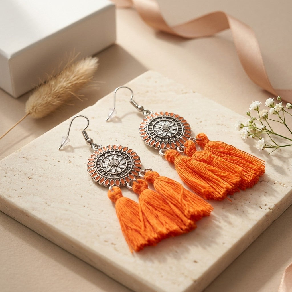 Aramat Jewels oranje boho oorhangers met kwastjes en zilverkleurig metaal. 75mm lang.