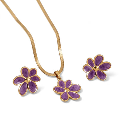 Aramat Jewels goudkleurige RVS sieradenset met paarse emaille bloemhanger en bijpassende oorstekers.