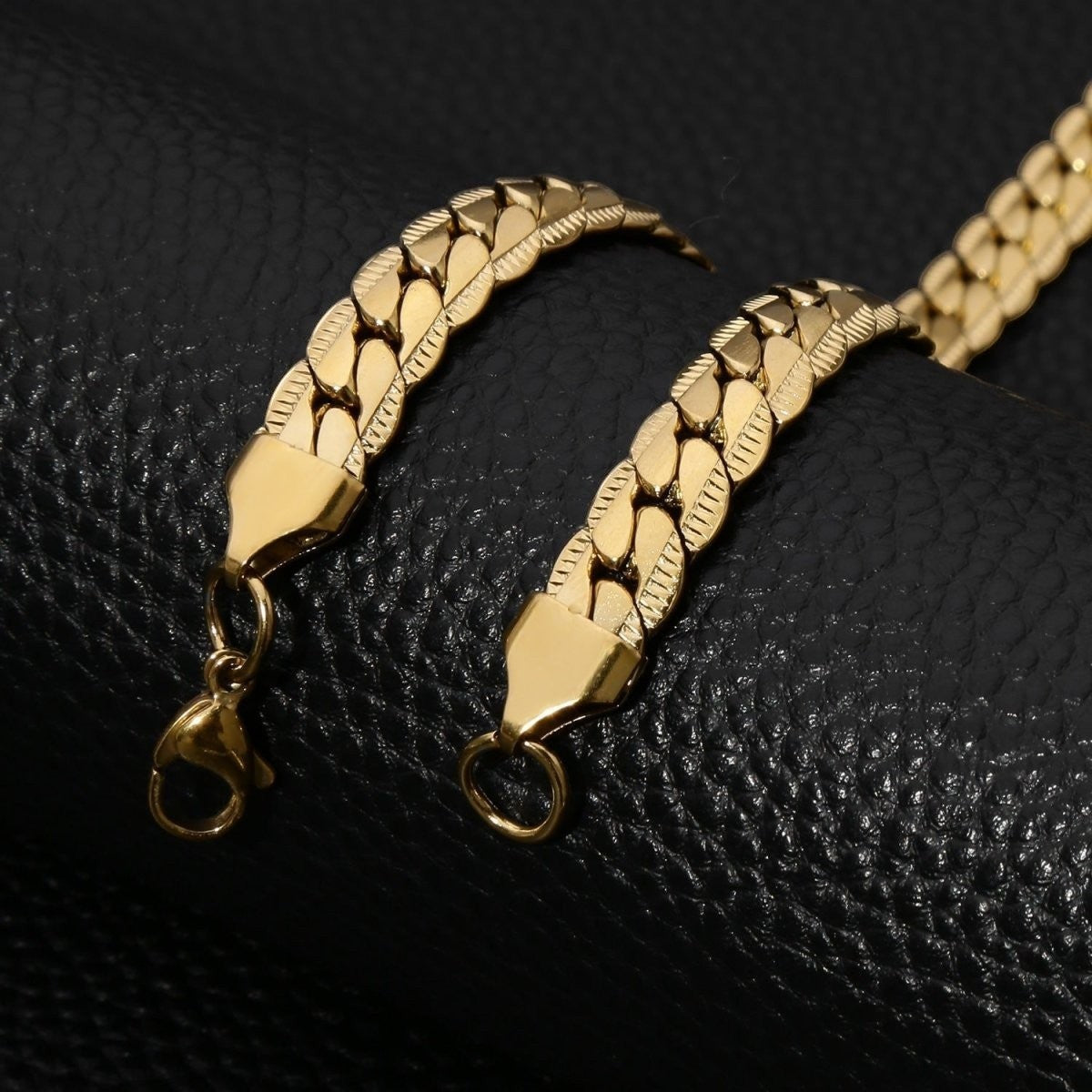 Aramat Jewels goudkleurige platte gourmet ketting van 5mm breed roestvrij staal met een gedetailleerde bewerkte rand.