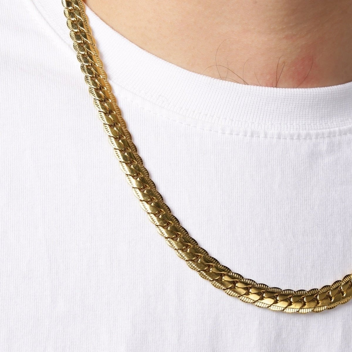 Aramat Jewels goudkleurige platte gourmet ketting van 5mm breed roestvrij staal met een stijlvolle bewerkte rand.