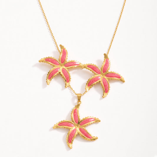 Aramat Jewels goudkleurige RVS sieradenset met roze emaille zeesterhanger aan een ankerketting