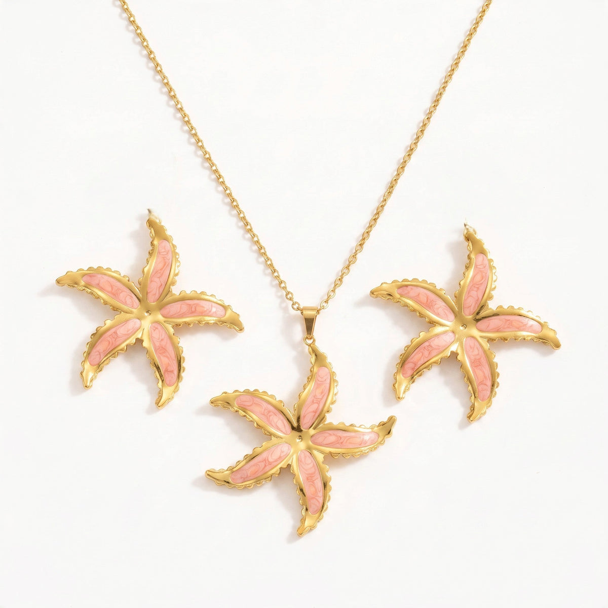 Aramat Jewels goudkleurige RVS sieradenset met roze emaille zeesterhanger aan ketting en bijpassende zeester oorbellen