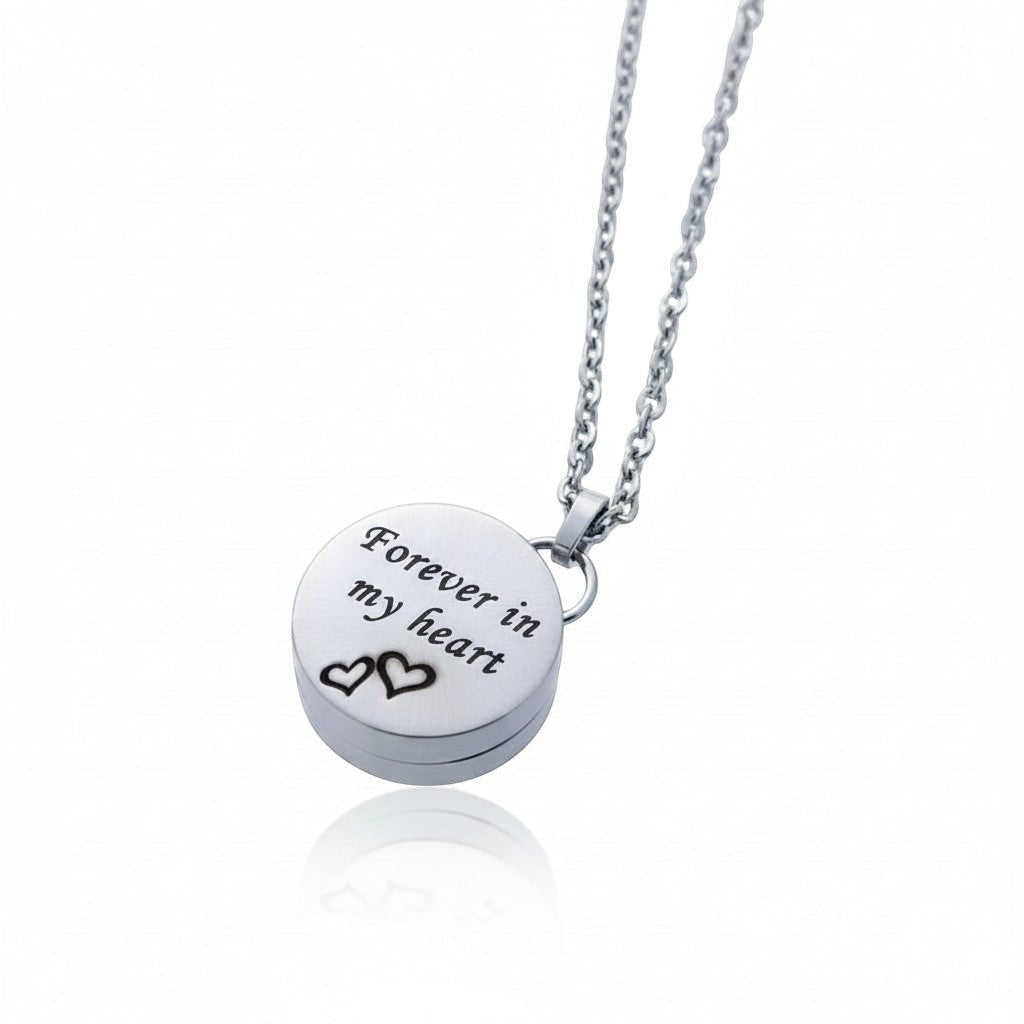 Aramat Jewels zilverkleurige RVS ashanger in hartvorm met de tekst 'Forever in my heart' en twee hartjes. Inclusief 50cm ketting.