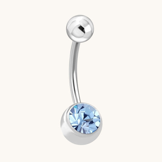 Aramat Jewels navelpiercing van RVS met een zilverkleurig staafje en een onderste balletje met blauwe zirkonia steen.