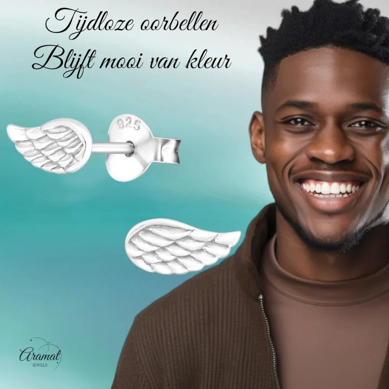 Aramat Jewels 925 sterling silver angel wing stud earrings with engraved feather details worn by a smiling man
