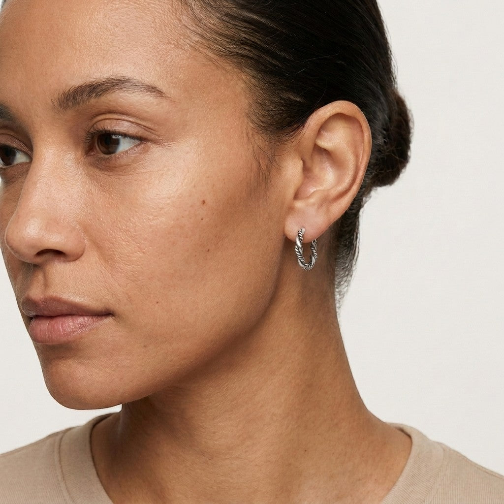 Aramat Jewels 16mm silver Bali hoop earrings with a twisted rope design, worn by a woman.