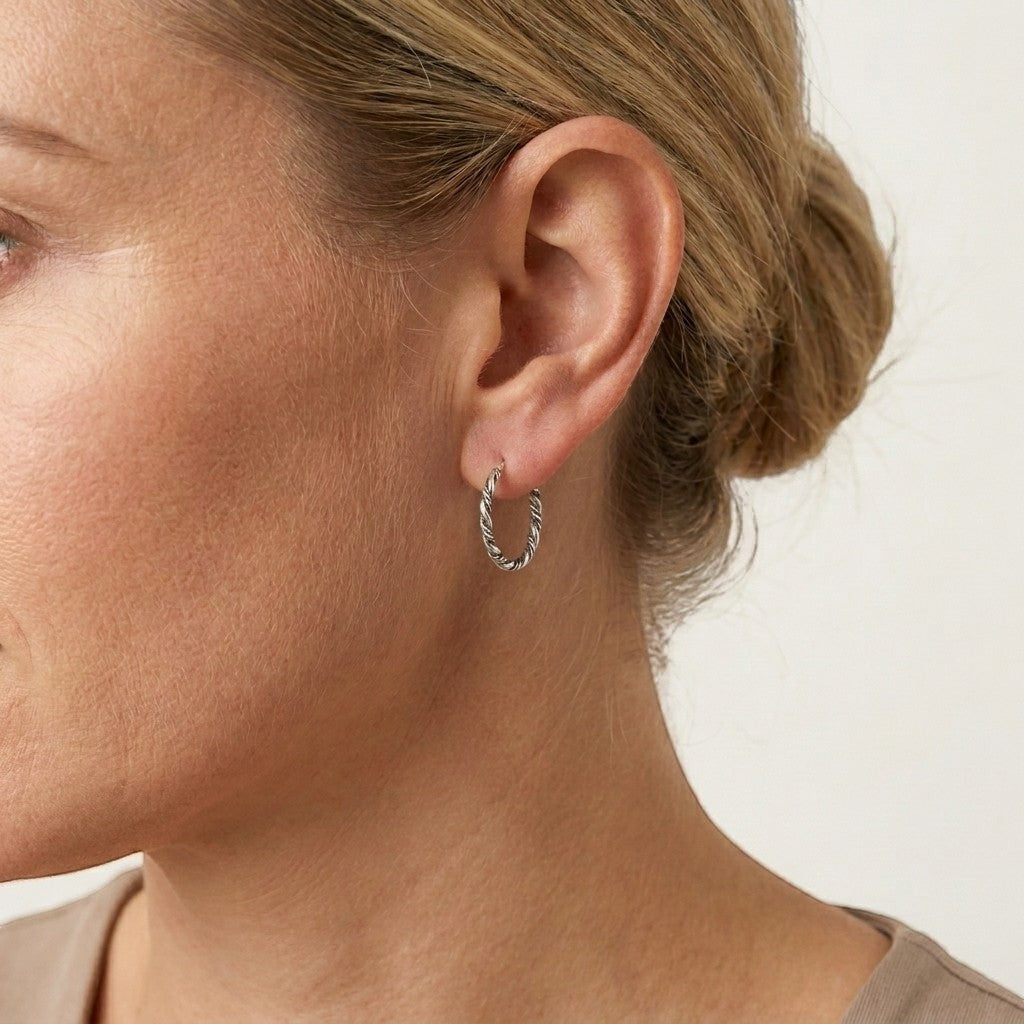 Aramat Jewels small silver Bali hoop earrings, 16mm diameter, twisted rope design, worn by a woman.