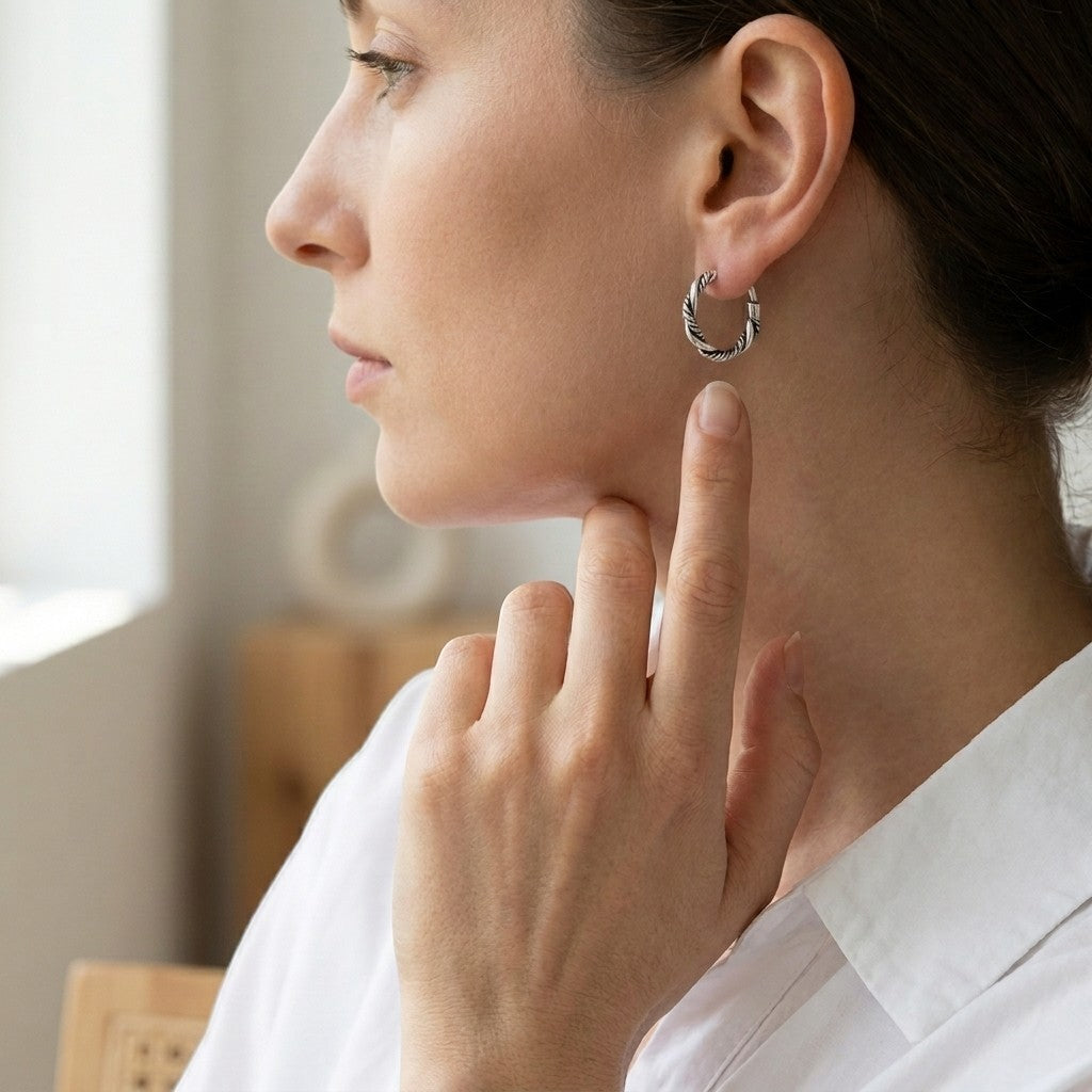 Aramat Jewels 16mm silver Bali hoop earrings with a twisted rope design, worn by a woman.