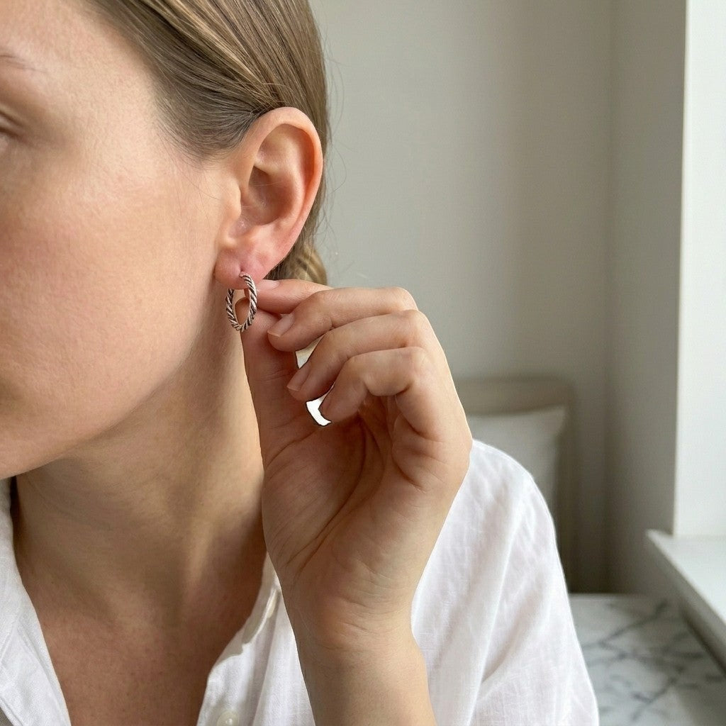 Aramat Jewels women's small 16mm silver Bali hoop earrings with a twisted rope design, worn by a model.
