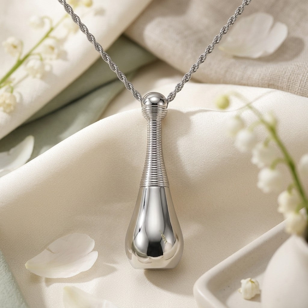 Aramat Jewels silver-colored cone urn pendant made of 316L steel with a rope chain. Features a ribbed neck and smooth teardrop base.