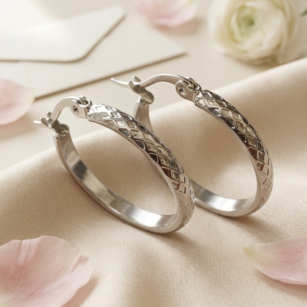 Aramat Jewels silver-tone stainless steel hoop earrings with a 30mm diameter and a diamond pattern.