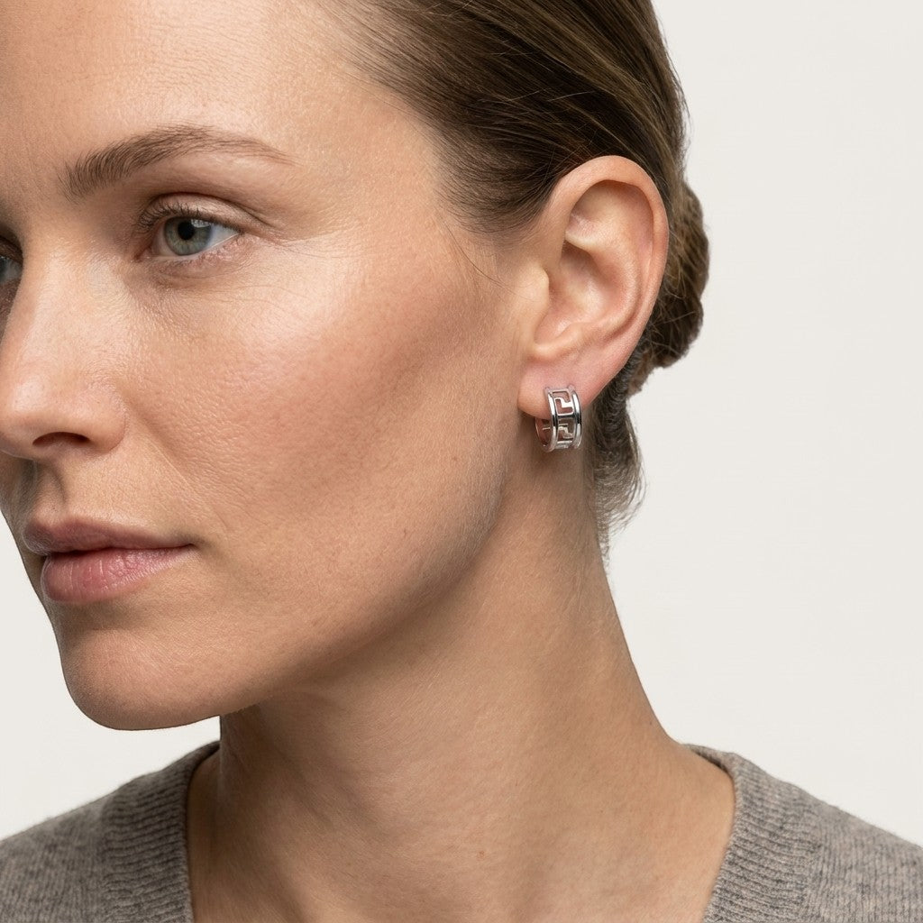 Aramat Jewels silver-tone stainless steel hoop earrings with Greek key motif, 20mm diameter.