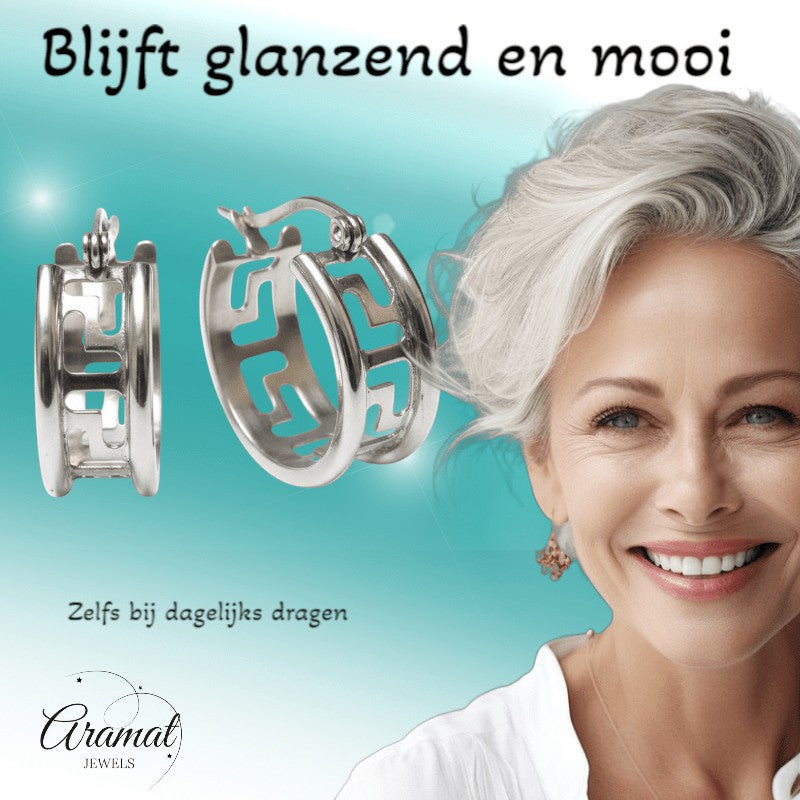 Aramat Jewels silver-tone stainless steel hoop earrings with Greek key design, 20mm diameter, worn by a smiling woman.