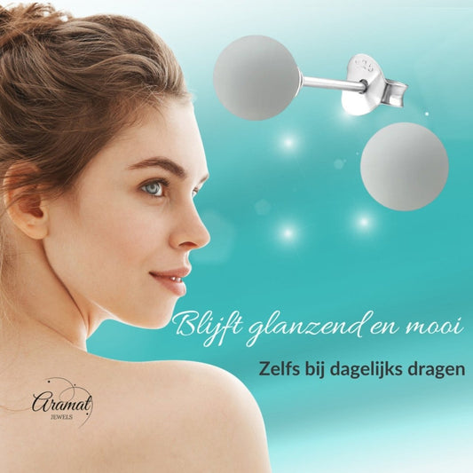 Aramat Jewels 925 silver stud earrings with light grey synthetic pearls, worn by a woman with a natural look.