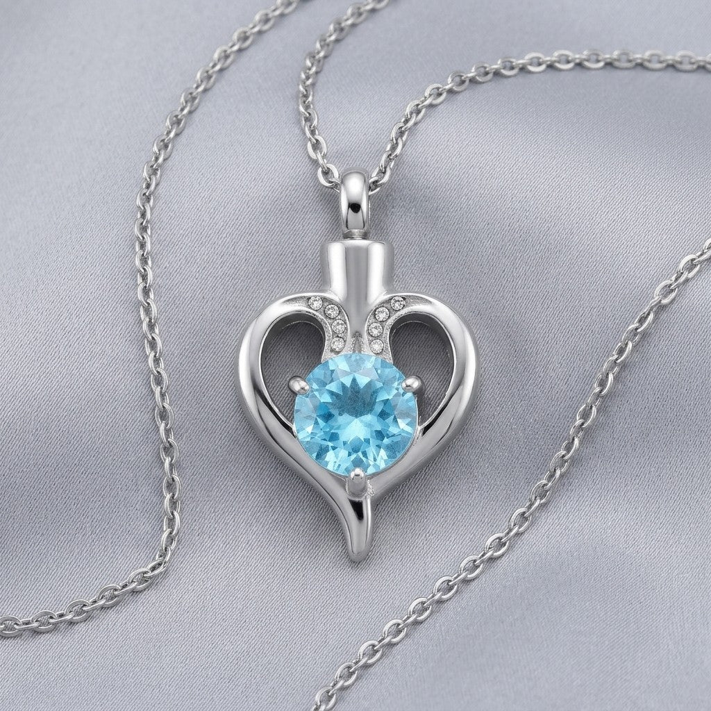 Aramat Jewels silver-tone stainless steel heart-shaped cremation pendant with a blue zirconia and small clear stones.