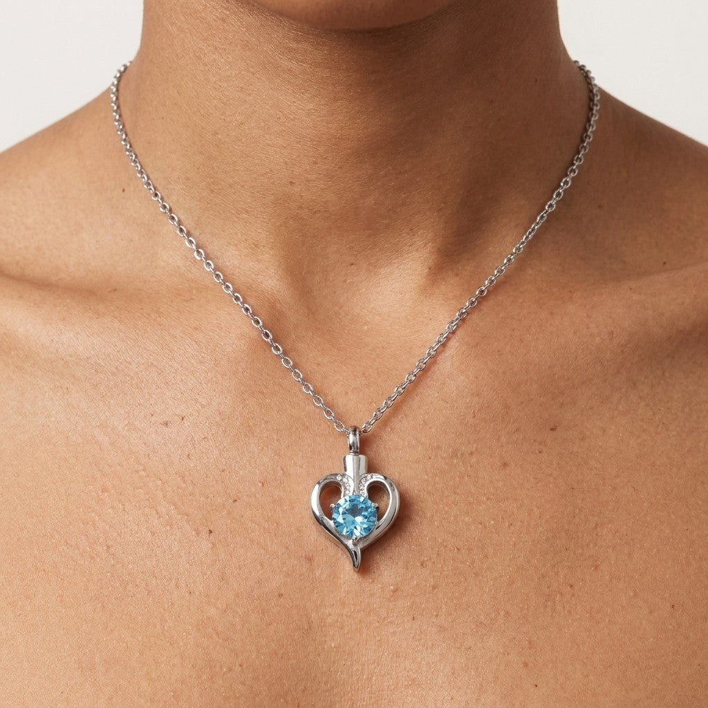 Aramat Jewels silver-tone stainless steel heart-shaped cremation pendant with a blue zirconia stone and screw closure.