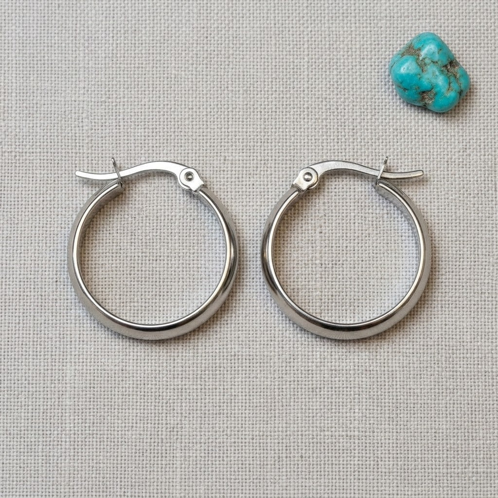 Aramat Jewels silver-tone stainless steel hoop earrings, 20mm diameter, smooth polished finish, hinged clasp.