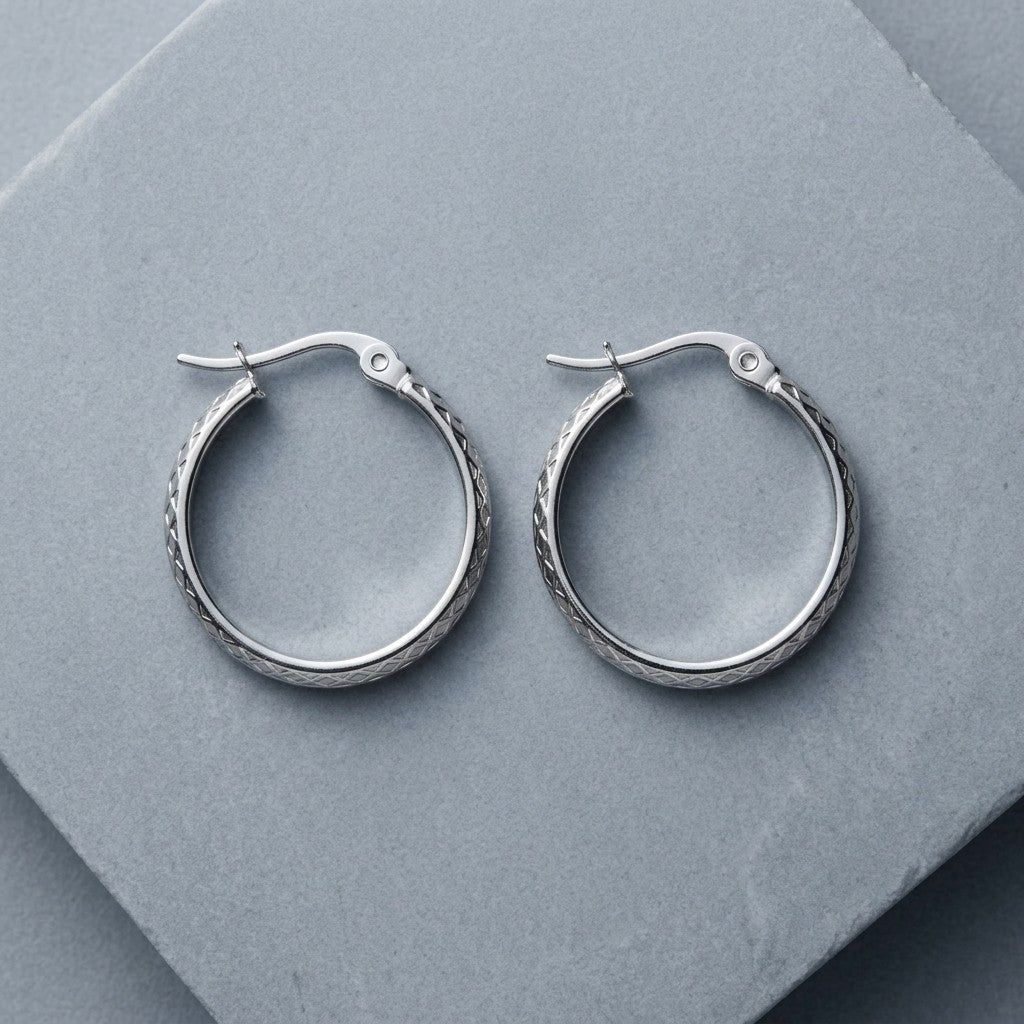Aramat Jewels silver-tone stainless steel hoop earrings with a 30mm diameter and a subtle diamond pattern.