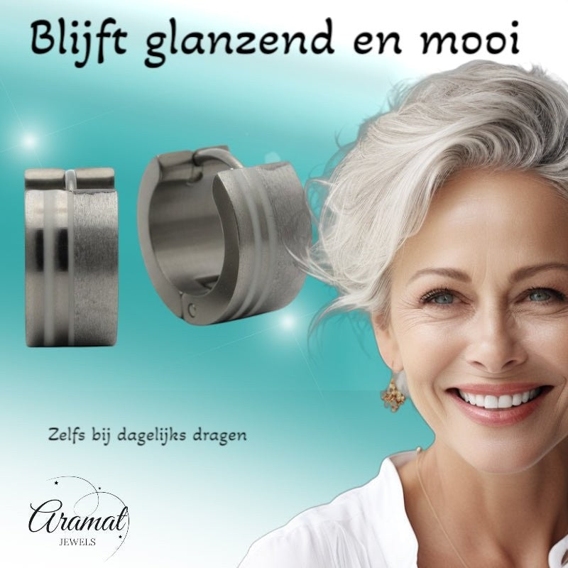 Aramat Jewels silver-tone stainless steel hoop earrings with sandblasted and polished stripes, 13mm. Model with grey hair smiles.