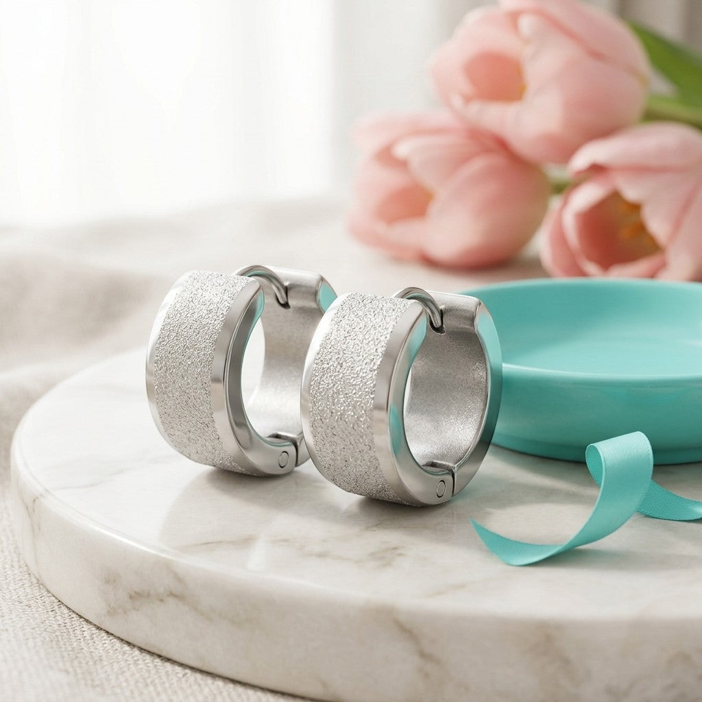 Aramat Jewels matte silver stainless steel hoop earrings with sandblasted stripe detail, 13mm diameter.