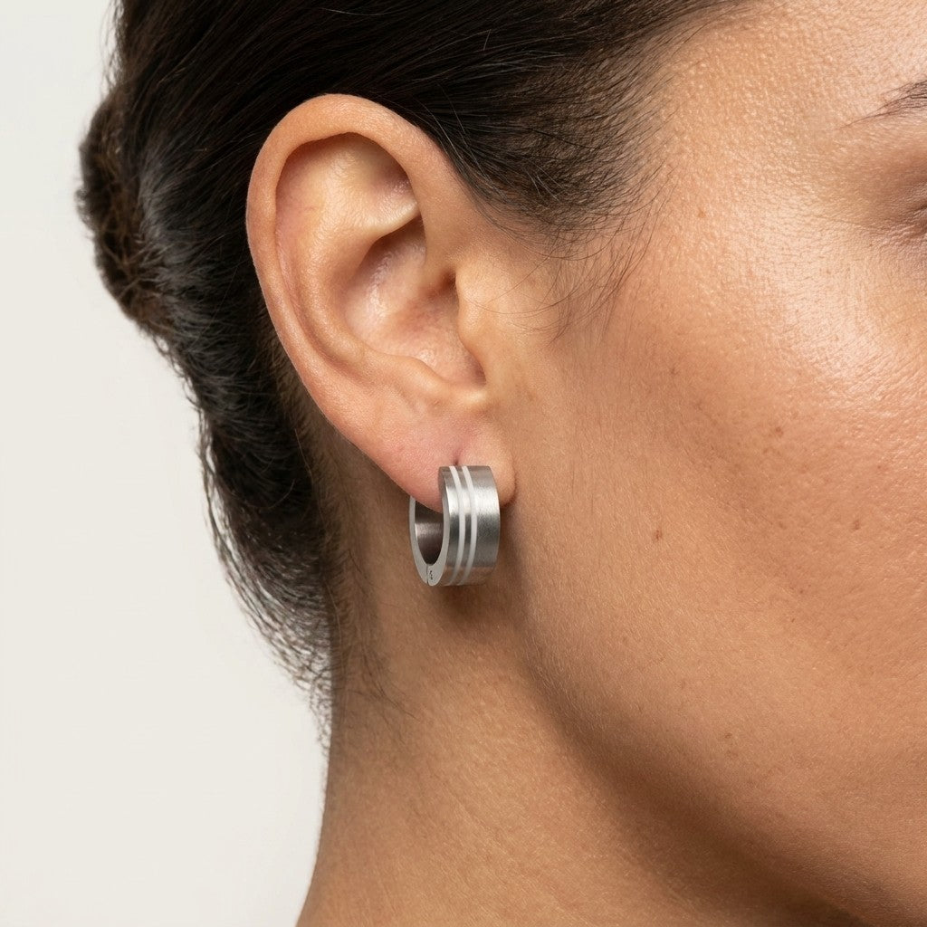 Aramat Jewels silver-tone stainless steel hoop earrings with sandblasted and polished striped finish, 13mm diameter.